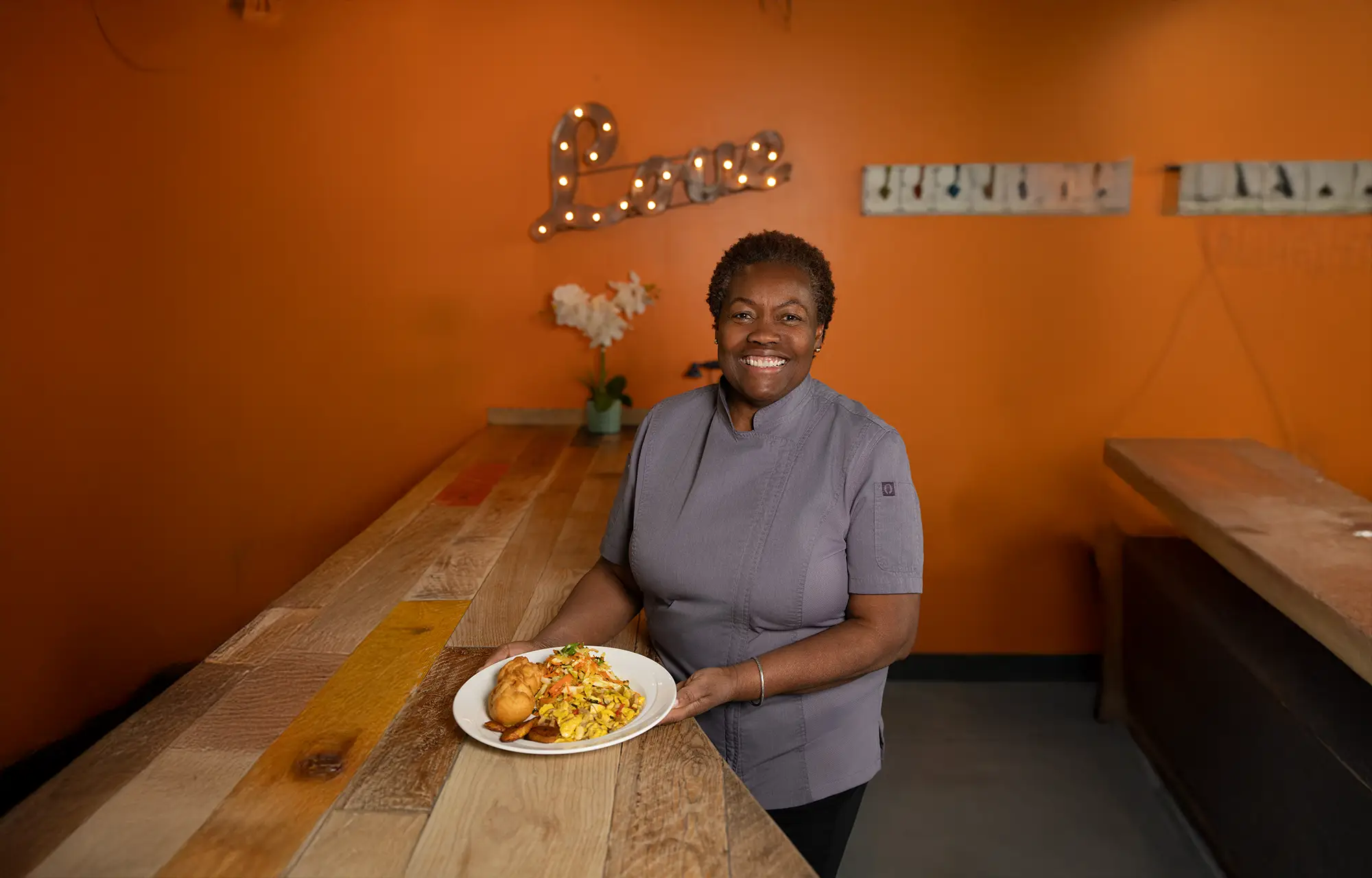 Chef Sheron Grant serving a plate at 11Hauz
