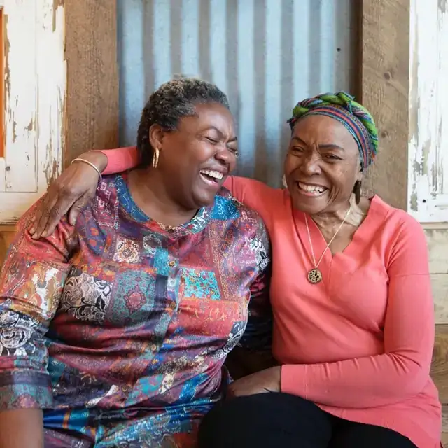Chef Sheron laughing and hugging a family member at 11Hauz