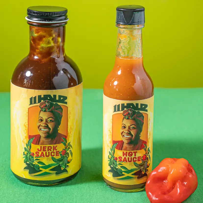 11Hauz Jerk Sauce and Hot Sauce bottles with a Scotch bonnet pepper